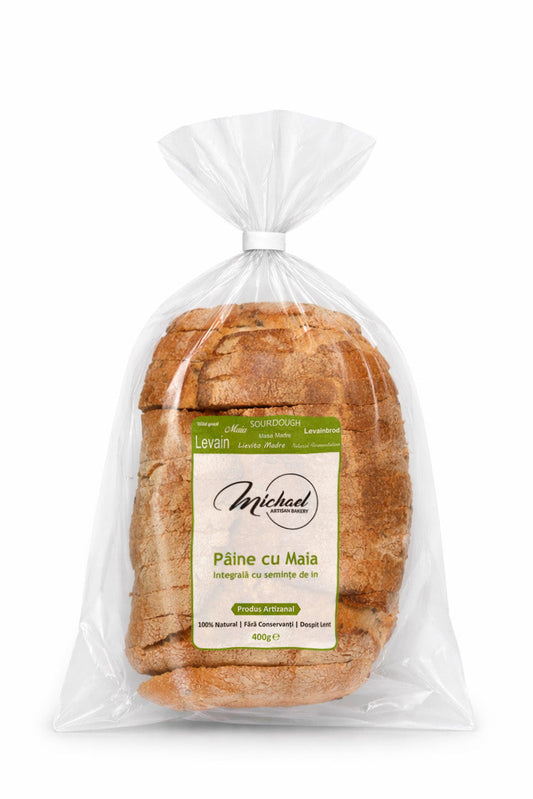 Pâine cu maia integrală cu semințe de in, produs artizanal din brutăria Michael Artisan Bakery, ambalată în folie transparentă pe fundal alb